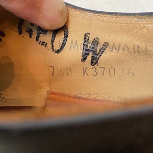 May include: Close-up of the inside of a black leather shoe. The insole is tan leather with black text that reads "7 1/2 K37036".