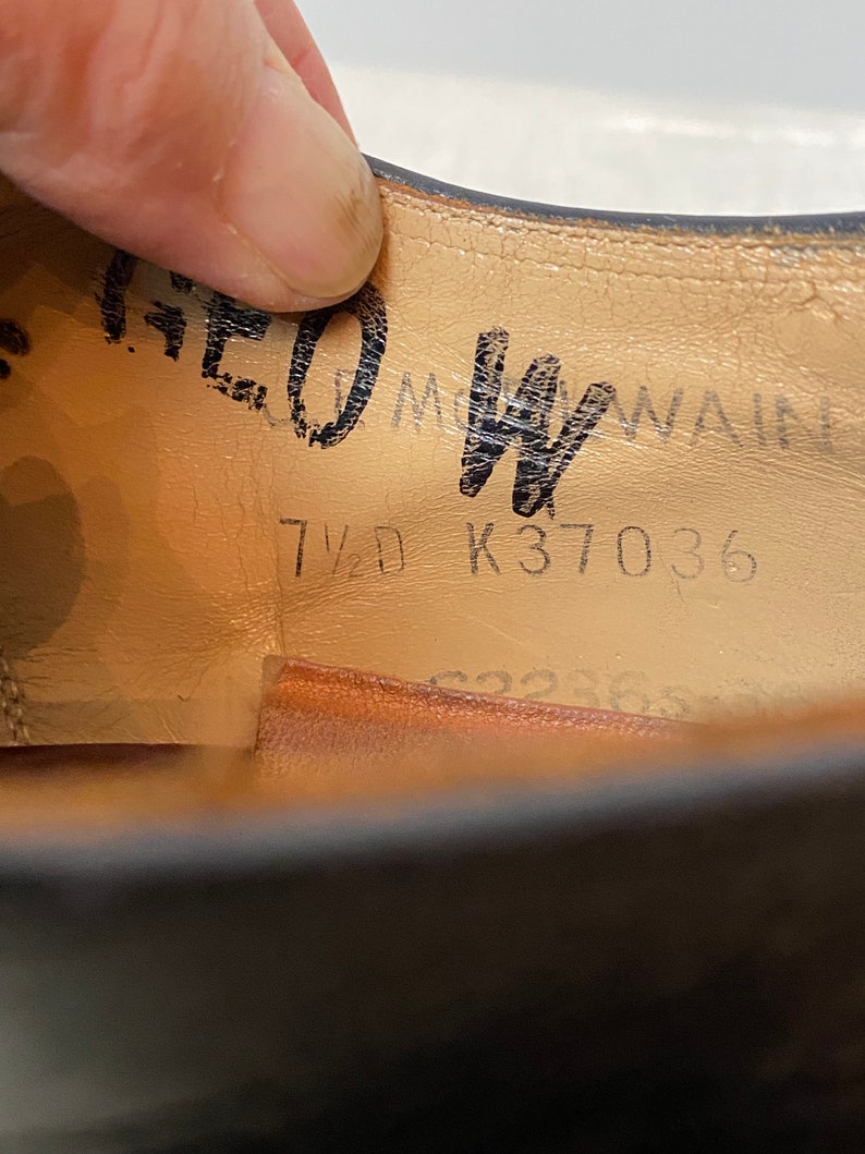 May include: Close-up of the inside of a black leather shoe. The insole is tan leather with black text that reads "7 1/2 K37036".