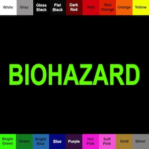 以下が含まれることがあります： 黒い背景の中央に明るい緑色で「BIOHAZARD」という文字が印刷されたカラーチャート。上下の縁には、White、Gray、Gloss Black、Flat Black、Dark Red、Red、Red Orange、Orange、Yellow、Bright Green、Green、Bright Blue、Blue、Purple、Hot Pink、Soft Pink、Gold、Silverとラベル付けされた色見本のグリッドが表示されています。