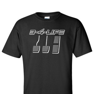 May include: Black t-shirt with a white graphic of three car pedals and the text "3-4-LIFE".