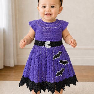 May include: A purple crochet dress featuring a black waistband with a white crescent moon accent, black bat appliqués on the skirt, and a black scalloped hem. The outfit includes a matching black headband with two pointed ears on top.