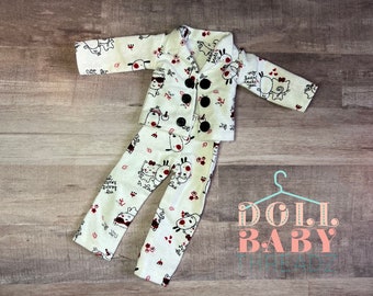 Puede incluir: Un conjunto de pijama blanco con estampado de animales de dibujos animados en negro y rojo. El conjunto incluye una camisa de manga larga con cierre de botones y pantalones a juego. La camisa tiene el texto "cute like" y "my heart beats for you" en las mangas. Los pantalones tienen el texto "in love" y "forever my love" en las piernas.