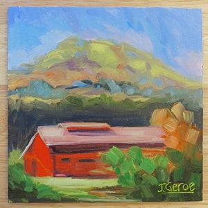 May include: A painting of a red barn with a pink roof in front of a green hill. The sky is blue and there are trees in the foreground. The painting is signed "J. Geroe" in the bottom right corner.