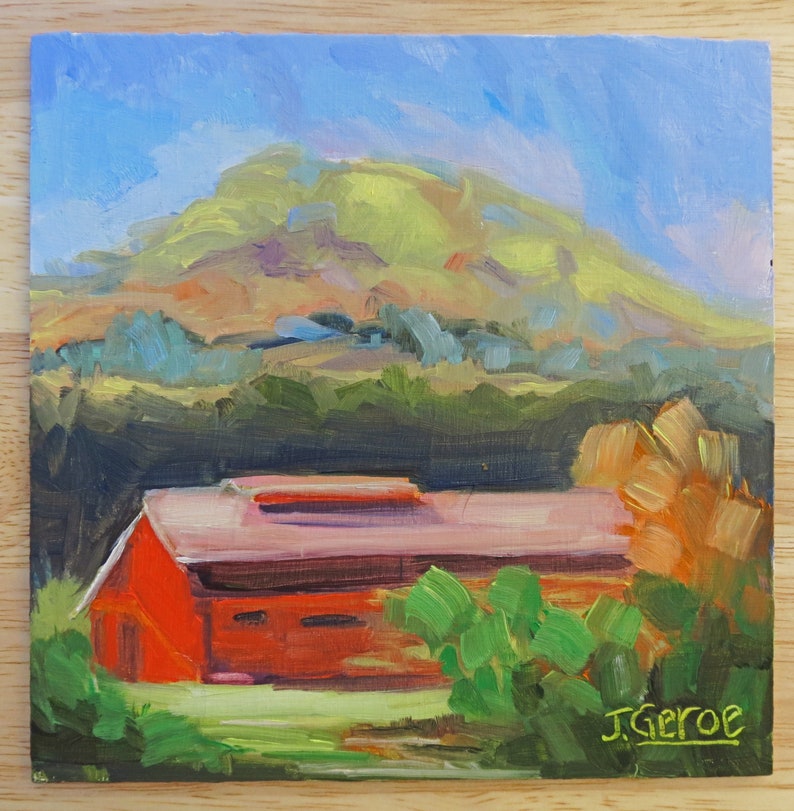 May include: A painting of a red barn with a pink roof in front of a green hill. The sky is blue and there are trees in the foreground. The painting is signed "J. Geroe" in the bottom right corner.