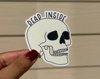 May include: A white skull sticker with the text "DEAD INSIDE" in black lettering.