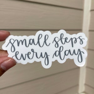 May include: A white sticker with the text "small steps every day" written in gray cursive lettering.