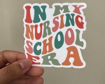 May include: A sticker with the text "In My Nursing School Era" in a retro font with colorful letters. The letters are in shades of red, orange, green, and blue.