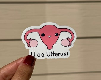 May include: A white sticker with a pink cartoon uterus holding two pink circles. The text "U do U(terus)" is below the cartoon.