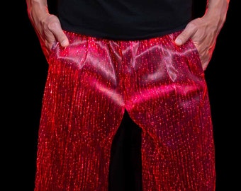May include: Red shorts with a shiny, iridescent finish. The shorts are made of a fabric that appears to be woven with thin strands of fibre optic cable.
