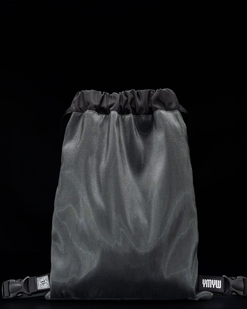 May include: A gray drawstring bag with black drawstrings and black straps. The bag has a white logo that says "YMWW".