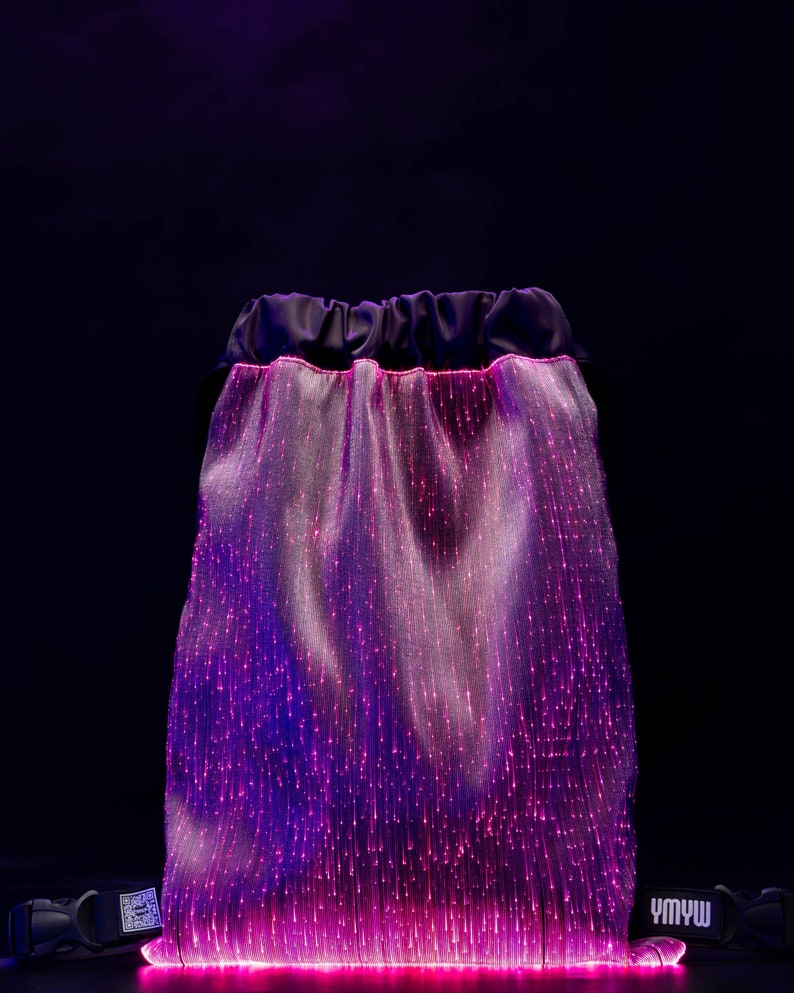 May include: A black drawstring bag with a pink and purple fiber optic light display. The bag has a black strap with the text "YMYW" printed on it.