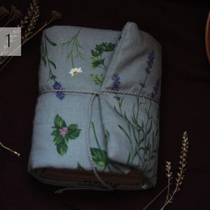 May include: A wrapped book with a floral design featuring lavender, daisies, and other greenery on a gray background. The book is tied with a string. The text "TYPE 1" is in a white box in the upper left corner.