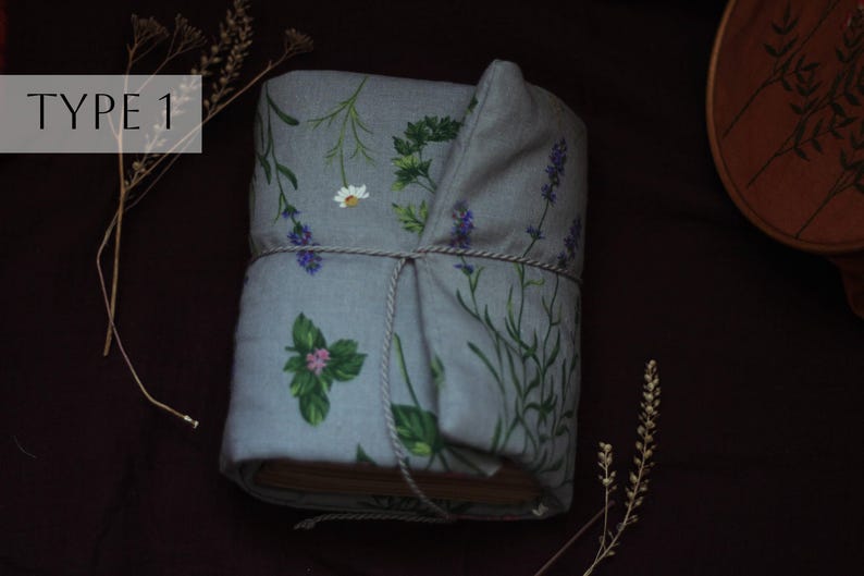 May include: A wrapped book with a floral design featuring lavender, daisies, and other greenery on a gray background. The book is tied with a string. The text "TYPE 1" is in a white box in the upper left corner.