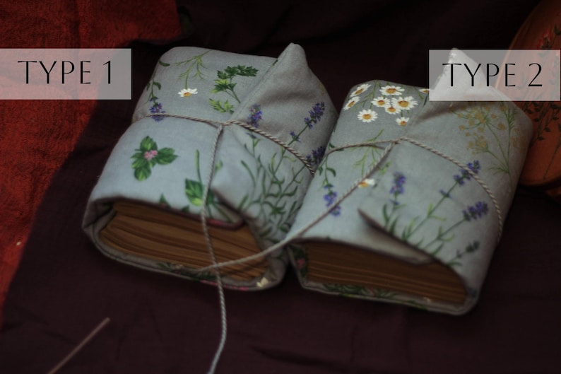 May include: Two fabric-covered books tied with twine. The covers are light blue with floral patterns, including herbs, lavender, and daisies. The text "TYPE 1" and "TYPE 2" are in white boxes on the top of the books.