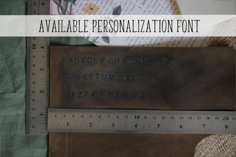 May include: A brown leather rectangle displays stamped alphabet letters and numbers, with a ruler showing inches. The text "AVAILABLE PERSONALIZATION FONT" is at the top. The image suggests customization options for leather goods.