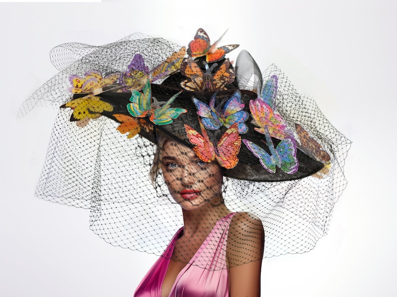 Gorgeous model wears a large statement fascinator with colorful butterflies and couture veiling.