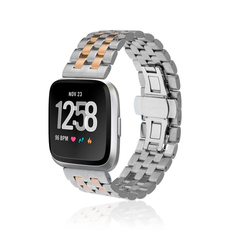 May include: A silver and rose gold metal watch band with a black face and a digital display showing the time as 12:58 and the date as NOV 23. The watch face also displays 96 BPM.