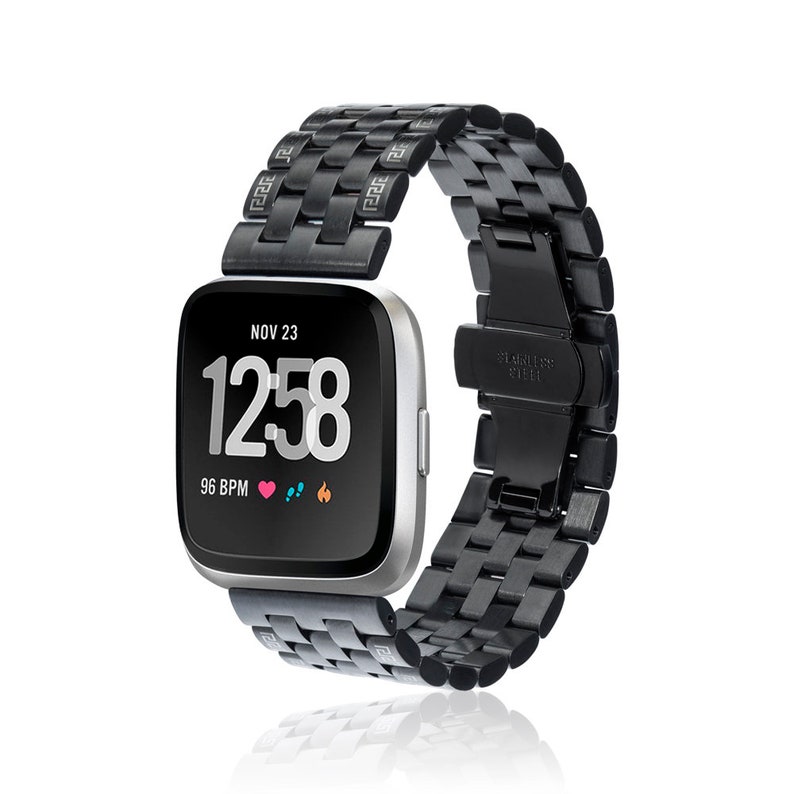 May include: Black metal band for a smartwatch with a black face displaying the date, time, and heart rate. The band has a stainless steel clasp.