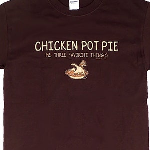 May include: A brown t-shirt with the text "Chicken Pot Pie My Three Favorite Things" and a cartoon chicken in a pie dish.