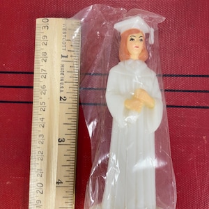 Decoración vintage para tarta de graduación de mujer, tiene cabello rubio, sostiene un diploma y lleva una toga y birrete blancos, hecha en China