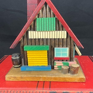 Vintage wooden log cabin style musical coin bank, made in Japan, door slides up and down to recover coins, coin slot next to chimney