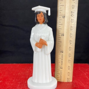 Decoración vintage para tarta de graduación de mujer, cabello oscuro, con toga y birrete blancos, sosteniendo su diploma, NOS