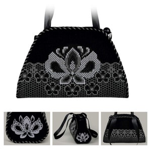 以下が含まれることがあります： 花柄の刺繍が施された黒と白のハンドバッグ。バッグにはトップハンドルとショルダーストラップが付いています。
