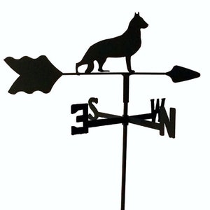 May include: Black metal German Shepherd silhouette weathervane with a directional arrow and compass points. The weathervane is mounted on a black metal stand.