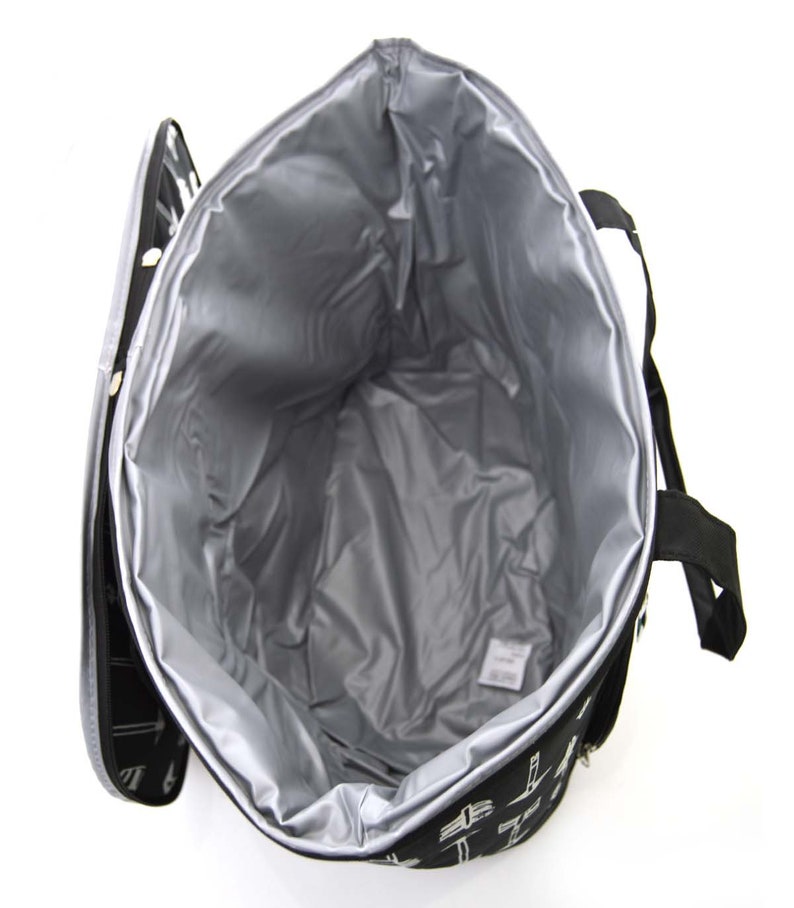 Może przedstawiać: Czarno-biała torba termoizolacyjna z zamkiem błyskawicznym i dwoma uchwytami. Torba jest otwarta, a wnętrze wyłożone jest srebrnym materiałem.