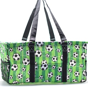 May include: Green and white tote bag with a soccer ball pattern. The bag has two black handles and a mesh pocket on the side.