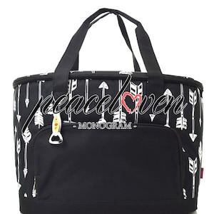 Może przedstawiać: Czarno-biała torba chłodząca z zamkiem błyskawicznym i g&oacute;rnym uchwytem. Torba ma wz&oacute;r białych strzałek i napis "peace love - MONOGAM -" z przodu.