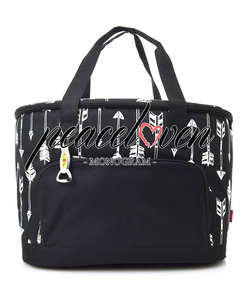 Może przedstawiać: Czarno-biała torba chłodząca z zamkiem błyskawicznym i g&oacute;rnym uchwytem. Torba ma wz&oacute;r białych strzałek i napis "peace love - MONOGAM -" z przodu.