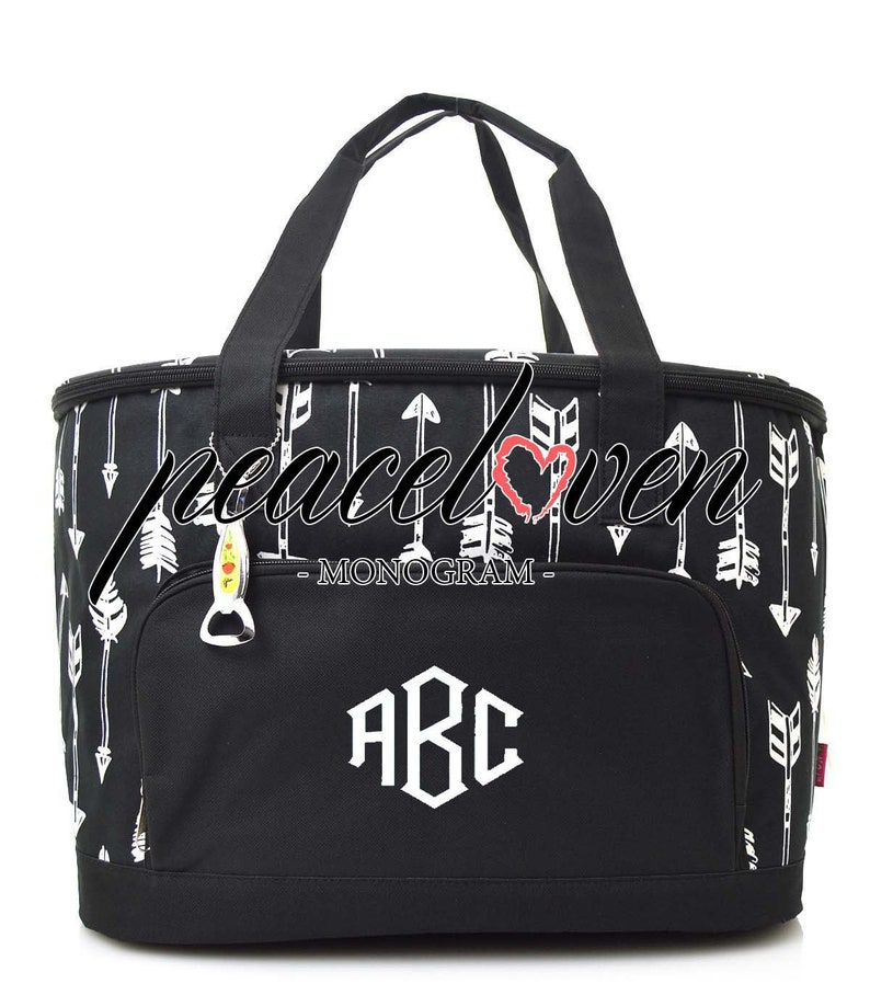 Może przedstawiać: Czarno-biała torba termiczna z zamkiem błyskawicznym i g&oacute;rnym uchwytem. Torba ma wz&oacute;r białych strzałek i tekst "MONOGAM" i "ABC" w kolorze białym.