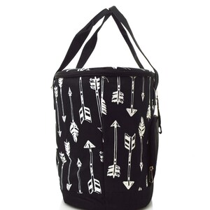 Może przedstawiać: Czarno-biała termoizolacyjna torba na lunch z wzorem białych strzałek na czarnym tle. Torba ma zamek błyskawiczny i g&oacute;rny uchwyt.