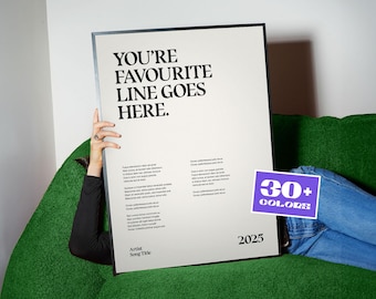 以下が含まれることがあります： 太字の黒いフォントで「YOU'RE FAVOURITE LINE GOES HERE」というテキストが入った大きなポスター。ポスターは黒い長袖シャツを着た人が持っています。小さな紫色のステッカーには「30+ COLORS」と書かれています。ポスターは緑色のソファに立てかけられています。