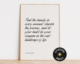 May include: A framed print with a light beige background and black text. The text reads: "Find the beauty in every moment, cherish the journey, and let your heart be your compass in the vast landscape of life." The print is signed "- ELARA BENNETT."