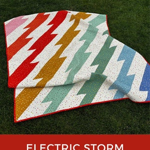 Puede incluir: Un patrón de colcha colorido llamado "Electric Storm" con un fondo blanco y un patrón en zigzag en tonos de rojo, naranja, amarillo, verde y azul. La colcha está doblada por la mitad y se encuentra sobre una superficie de hierba verde. El texto "ELECTRIC STORM" está en letras blancas sobre fondo rojo. El texto "QUILT PATTERN" está en letras blancas sobre fondo rojo. El texto "ALLISONRAMSING.COM" está en letras blancas sobre fondo rojo. El texto "@ALLISON.RAMSING" está en letras blancas sobre fondo rojo.
