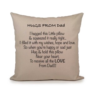 May include: A beige pillow with a black message that reads "HUGS FROM Dad I hugged this Little pillow & squeezed it really tight.... I filled it with my wishes, hope and love. So when you're happy or sad just Hug & hold this pillow Near your heart, To receive all the LOVE From Dad!!!"