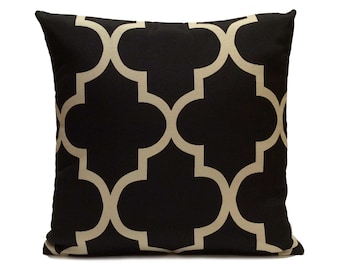 Könnte beinhalten: Schwarzes und cremefarbenes Kissen mit geometrischem Muster. Das Muster ist ein sich wiederholendes Design aus Quadraten und Kreisen.