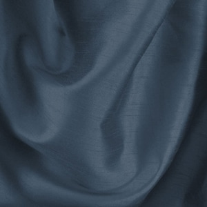 May include: A close-up of a draped fabric in a deep, muted blue-grey hue. The material has a subtle sheen, with visible textures and folds creating shadows and highlights. The overall effect is one of elegance and softness, with a flowing appearance.