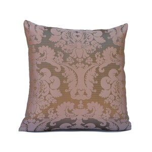 May include: A decorative throw pillow with a damask pattern in shades of pink and brown.