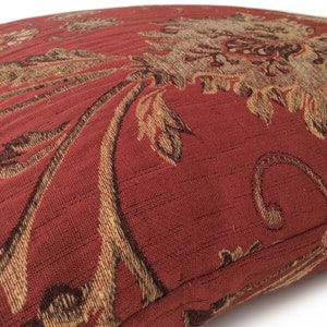 May include: Red and gold patterned throw pillow with a floral design.