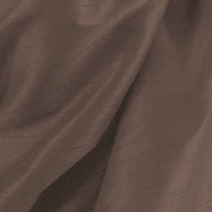 May include: A close-up of a smooth, brown fabric with a subtle sheen. The fabric has a slightly textured surface and is draped in soft folds.