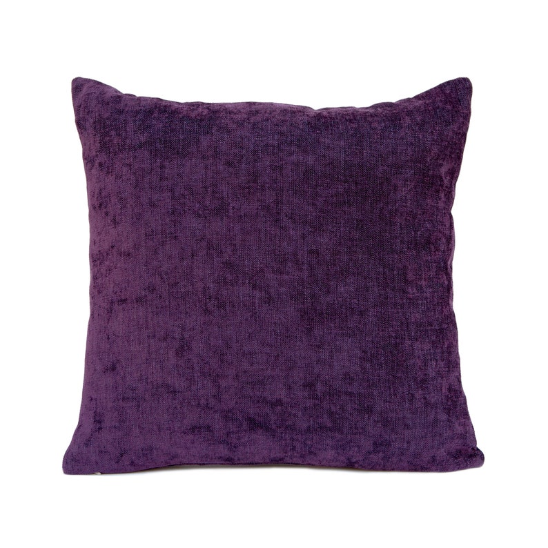 May include: A deep purple square throw pillow with a soft, textured fabric.