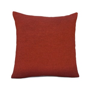 May include: A solid red throw pillow with a textured fabric surface.