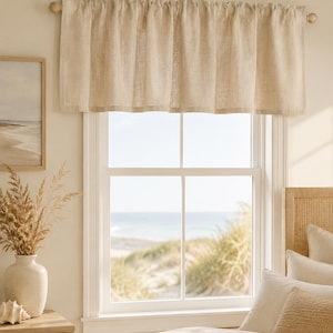 May include: A beige window valance made of a textured fabric with a rod pocket header. The valance is gathered along a wooden curtain rod, creating soft vertical folds across the top of the window frame, providing a simple window covering.