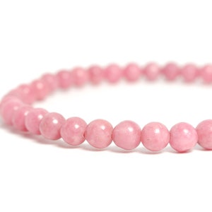 May include: A pink gemstone bracelet made of round beads. The bracelet is made of natural stones and is a popular choice for those seeking a stylish and meaningful accessory.