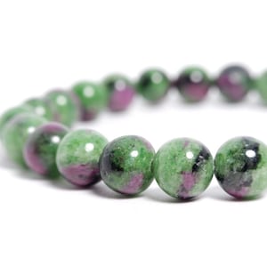 May include: A green and pink gemstone bracelet with round beads. The bracelet is made of natural stones and has a polished finish.