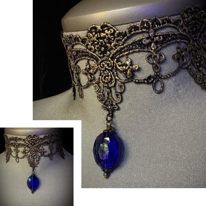 Pode incluir: Um colar de choker de renda preto e dourado com um pingente de pedra preciosa azul.