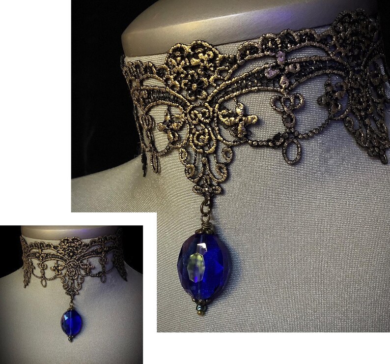 Pode incluir: Um colar de choker de renda preto e dourado com um pingente de pedra preciosa azul.